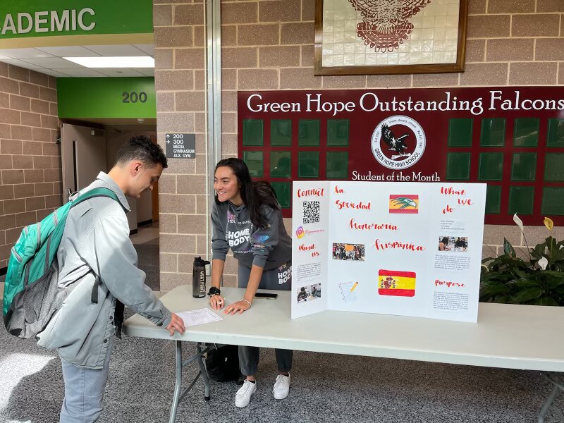 SHS member Alexa Bernard sets up a booth at Green Hope High School to spread awareness about Hispanic heritage.