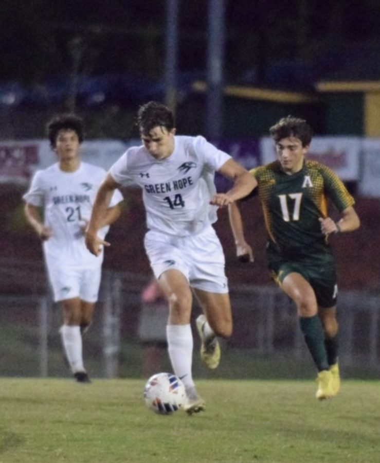 Adam Granai dribbles up the soccer field at an away game against Apex High School.