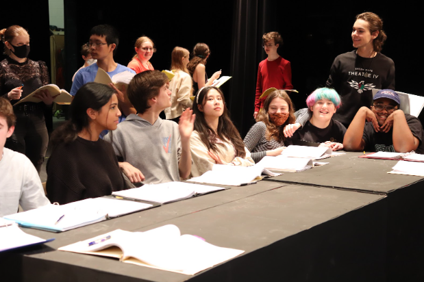 Actors go through their lines at a reading, learning it as they progress through the script.