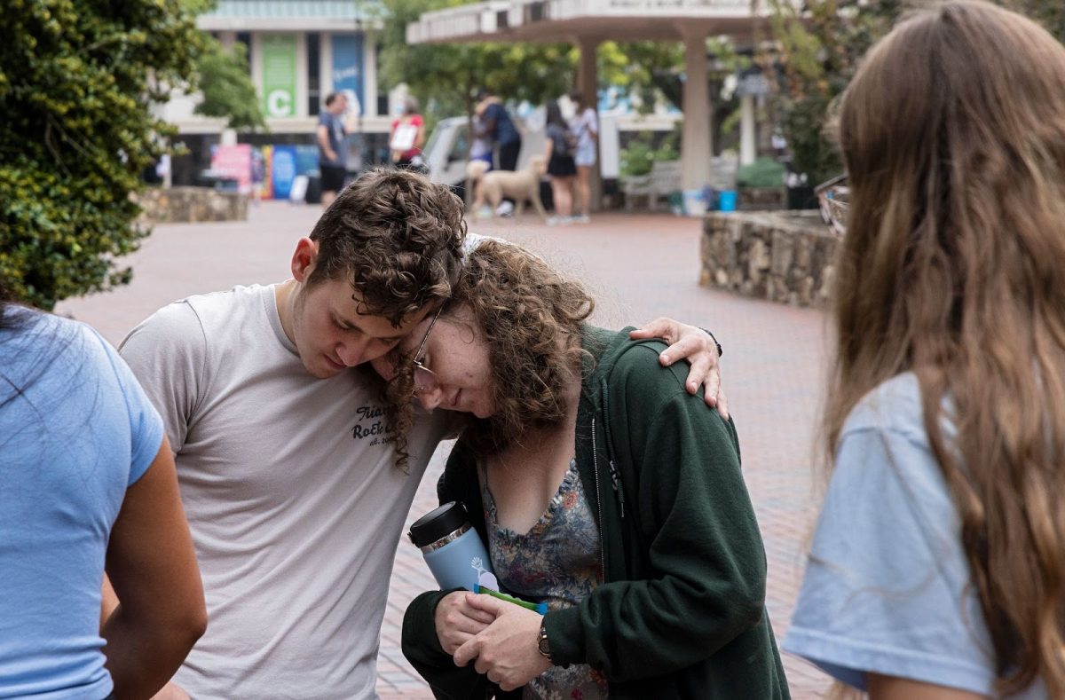 First-year students Lucas Moore and Katie Fiore comfort one another following Mondays tragic shooting at the University of North Carolina at Chapel Hill. Photo used with permission from News & Observer.