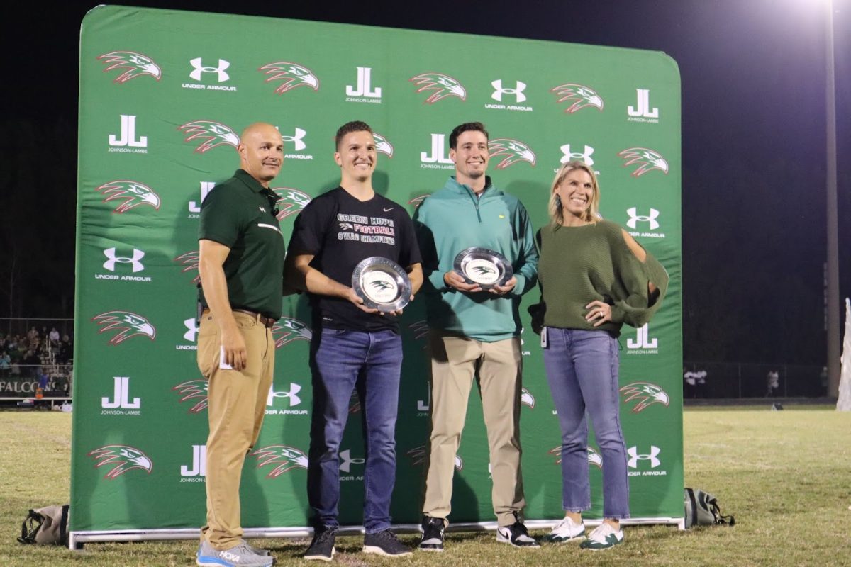 Troy Masloski and Mitch Spence holding their awards while standing with the athletic director, Mr. Robby St. John and the principal Ms. Alison Cleveland. Both men said they felt honored at this moment.