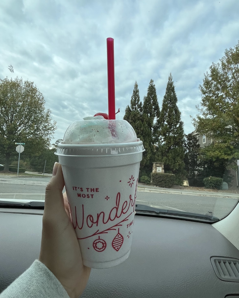 The Chick-fil-A Peppermint Milkshake is delivered in a white cup with cursive red lettering that says, It’s the most wonderful time. 