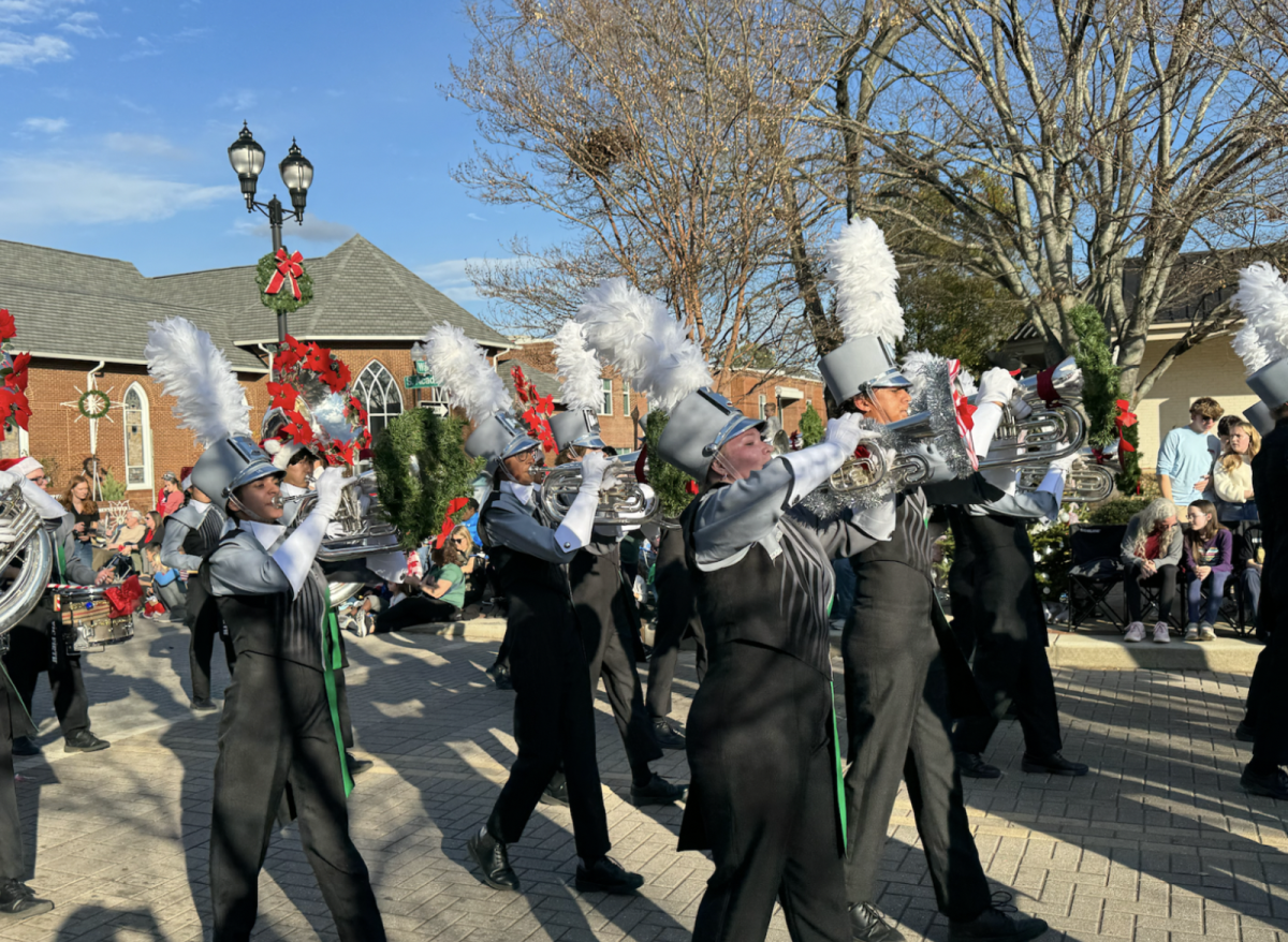 Green Hope marching band was part of the parade with instruments, flags and shotguns.