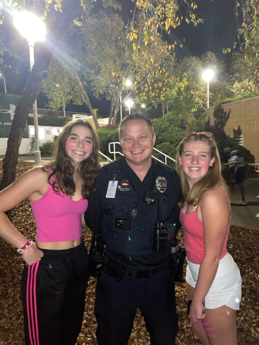 Officer Crady with students Luci Mertens (pictured left) and Annabella Monge (pictured right) at a football game.