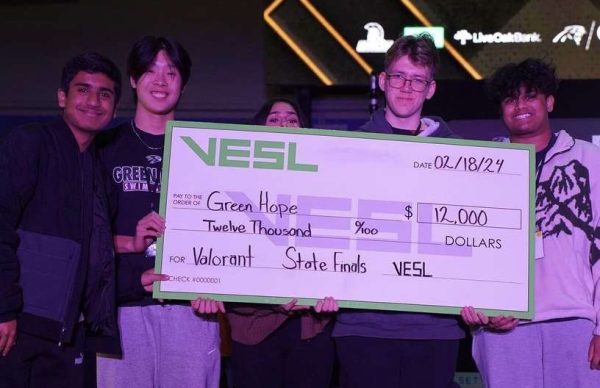 Dhruv Dhiran (‘24), Ryan Chen (‘24), Anoo Prabhala (‘24), Joshua Elbertson (‘24) and Vishnu Boggala (‘24) triumphantly hold up their esports check on stage in the Koury Convention Center in Greensboro, NC. Photo used with permission from Vishnu Boggala.