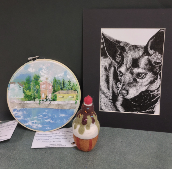 The ink portrait, embroidery piece and fabric pastry that won Green Hope students three awards at the Junior Womens Club of Raleigh art competition. Photo used with permission from Ms. Melissa Poppe. 