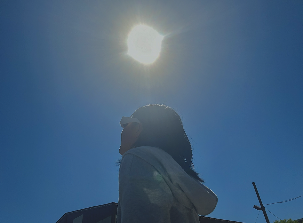 A viewer watches the solar eclipse through her ISO-certified eclipse glasses. These special glasses can be purchased from various stores or disseminated at events. 