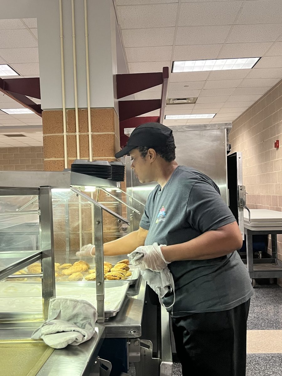 The cafeteria manager, Ms. Lakisha Howard, getting ready to serve breakfast to students with some chicken biscuits.