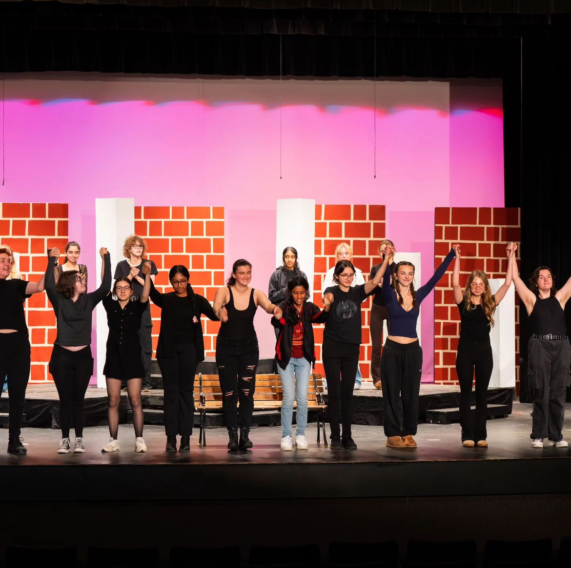 The tech crew hold their hands high as they receive a raucous applause from the lively crowd.
