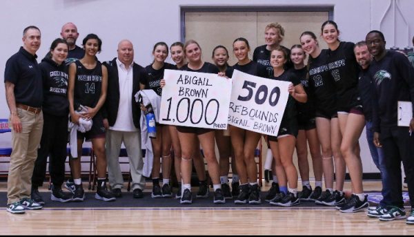 Players and coaches from the varsity girls basketball team celebrate Abigail Brown ('25) on a milestone game. Photo from @EricHemming X/Twitter