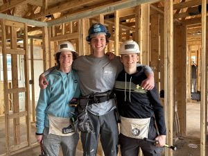 Caption: Tyler Herrick (center) poses with fellow members of the Habitat club Ryan Bereda (‘25) and Jacob Gordon (‘25) at a build site. Photo used with permission from Tyler Herrick. 