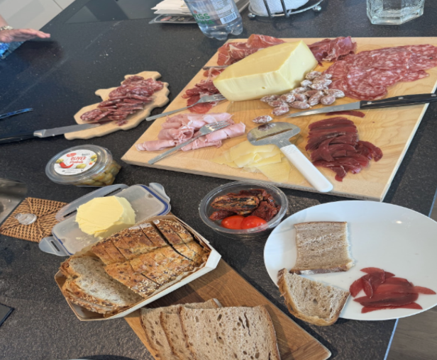 Charcuterie board with different varieties of meats, cheeses and breads. 