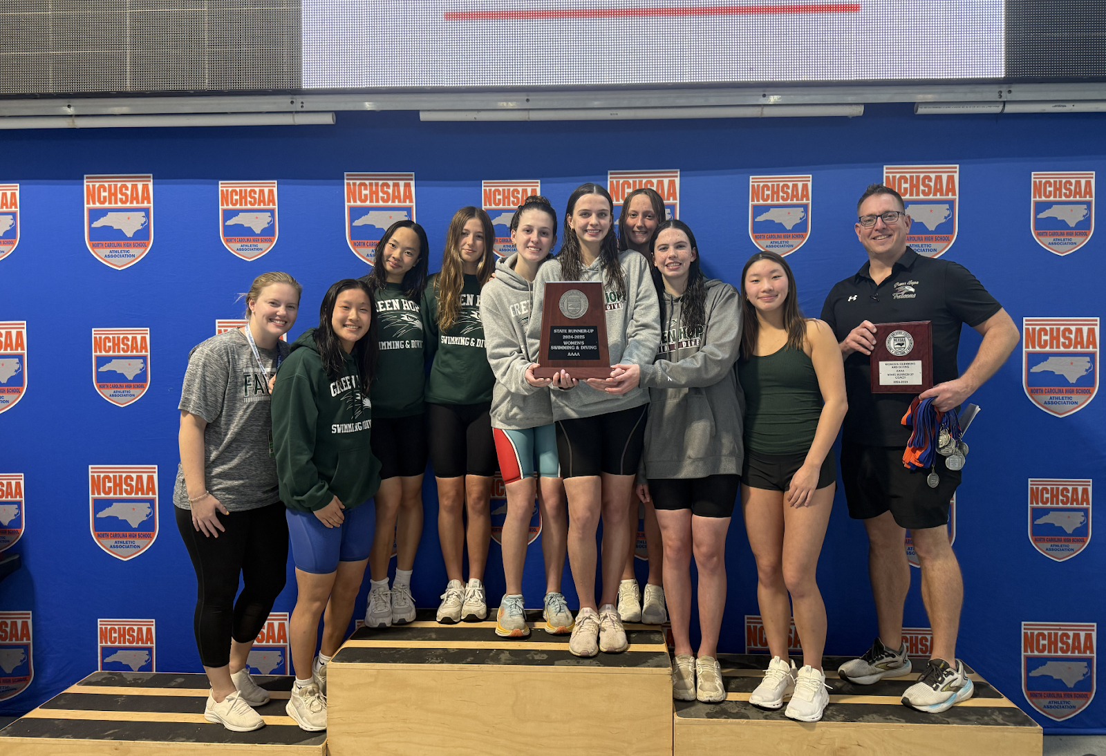 The women’s team poses with their medals and trophy after being named second in the State.