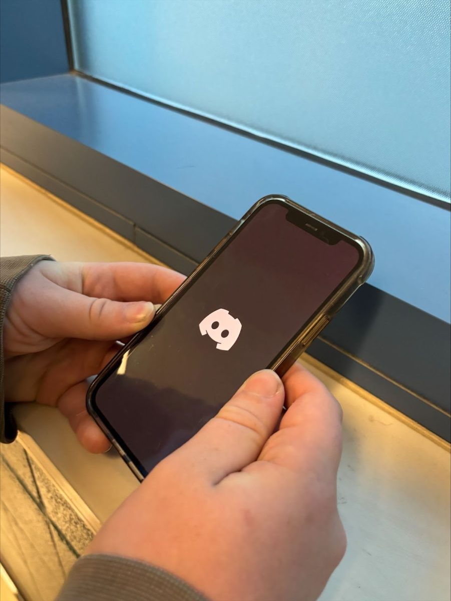 A person opens Discord on their phone: a popular text, voice and video chat platform originally intended for gamers but now used by diverse groups of various interests.