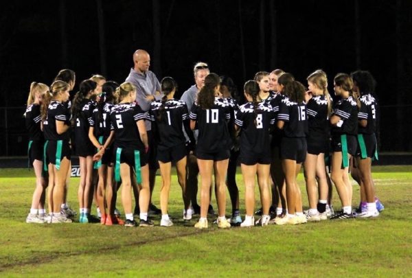 The flag football team huddles together to discuss tactics going into the next play. Photo used with permission from Mia Wilcocks.