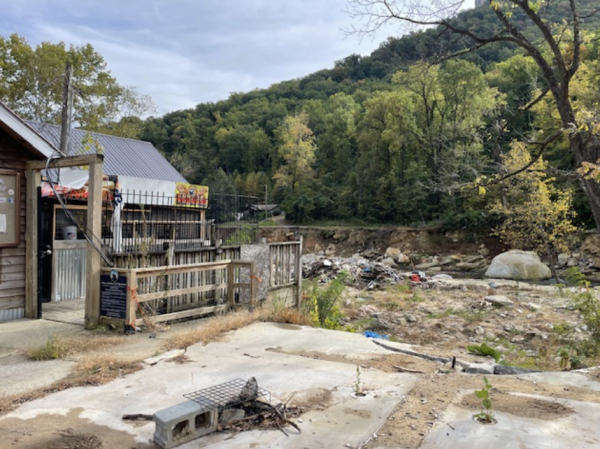 A completely destroyed section of downtown Chimney Rock over a year after the hurricane as debris is scattered in the river in the background.