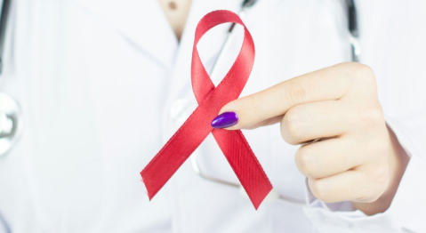 A red ribbon is the awareness symbol for AIDS. Photo used with permission from Bremix Studios on Unsplash.