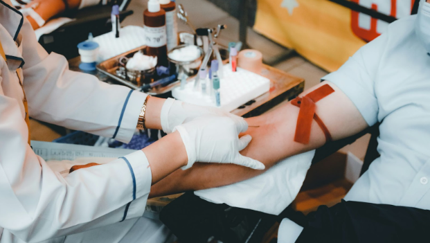 A donor sits ready in a calm position as the phlebotomist, a health care professional, inserts the syringe and draws blood from the vein. Photo by Nguyễn Hiệp on Unsplash.
