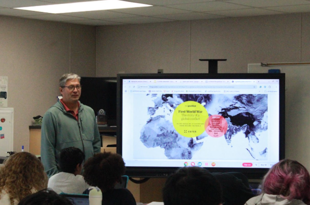 Dr. Sarchet stands in his classroom, creating an environment where students can explore history, grow as learners, and connect past events to the world around them. Photo used with permission by Jerry Sarchet.