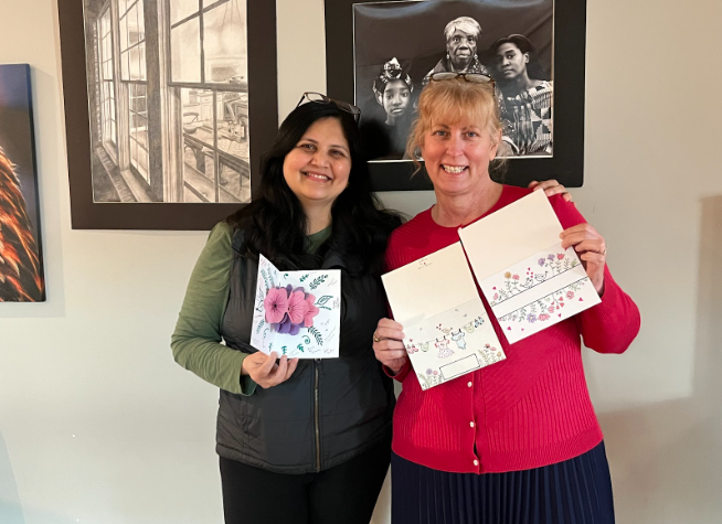 Mrs. Scelsi and Ms. Krave pose with handmade cards created by them for our school community. Photo taken by Anna Talassio.