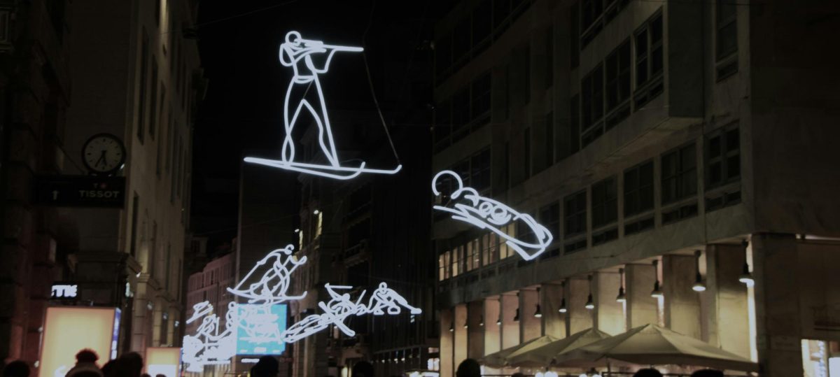 In the streets of Milano Cortina, light figures of each Winter Olympics sport are displayed, creating a beautiful atmosphere for the games. Photo used with permission from Mandylin via Unsplash.