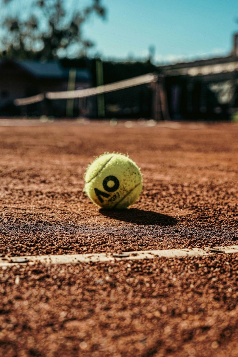 The Australian Open has a signature logo that they put on all of the balls used in the tournament. The tournament was historically played on a grass court, but transitioned to a hard court in 1988. Used with permission from The Drink Break on Unsplash.