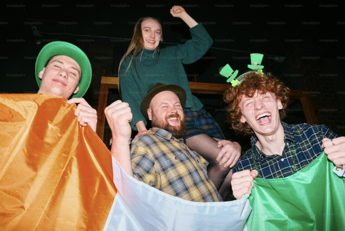 A company of friends in an Irish pub with St Patrick’s outfits and decorations. Photo used with permission of Andrej Lišakov and accessed through Unsplash.