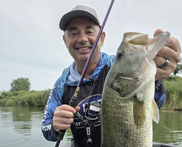 Jim Crowley is pictured holding a Largemouth Bass while on tournament water. Photo used with permission of Jim Crowley on Unsplash. 
