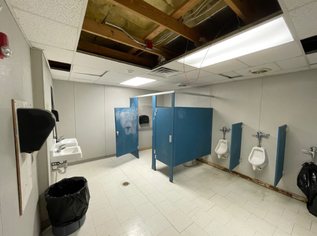 The Mod 1 men's bathroom is showing increased signs of wear. Wires hanging from the ceiling, out-of-order urinals and many more problems are shown in this image. 