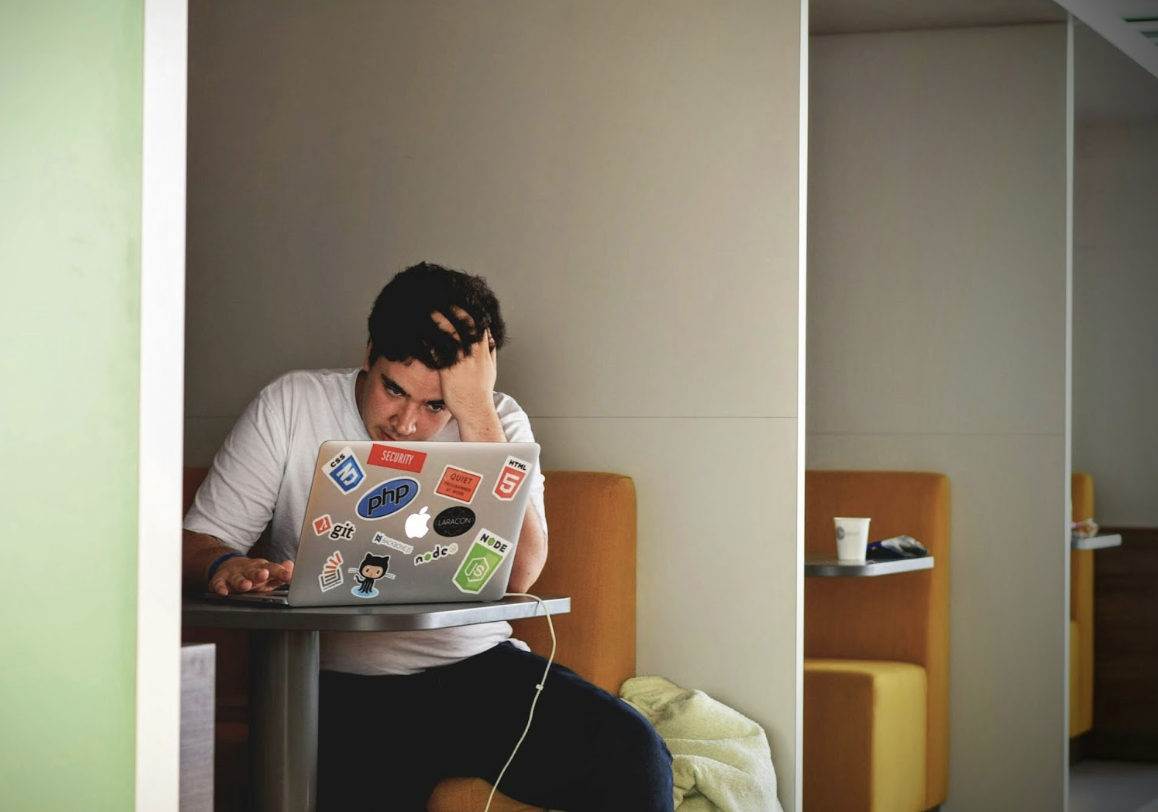 A high school senior anxiously refreshes his computer as he waits for college decisions. Photo used with permission from Tim Gouw via Unsplash.