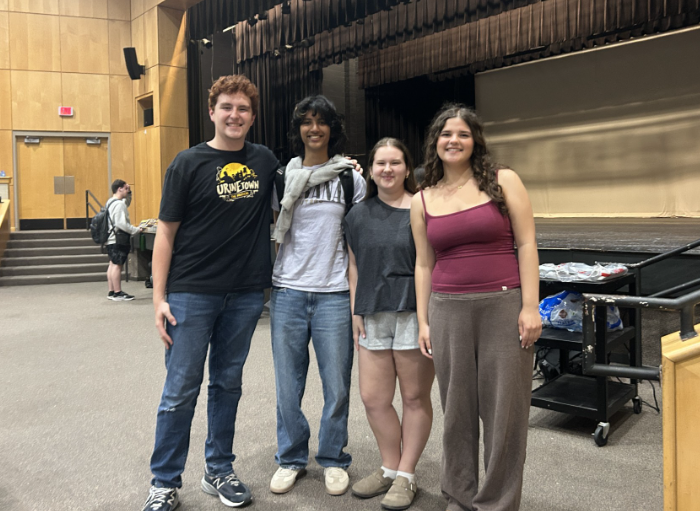 Club leaders and play directors Danielle Sanchez ('26), Sarah George ('26), Brian Pollard ('26) and Kat Walker ('26) pose in front of the stage on which their play will be performed.
