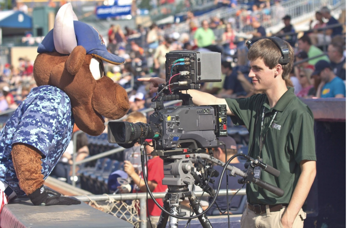 Image of Explorer Post 50 member filming on the first base line, joined by Bulls mascot Wooly Bull. Image used with permission from Explorer Post 50.