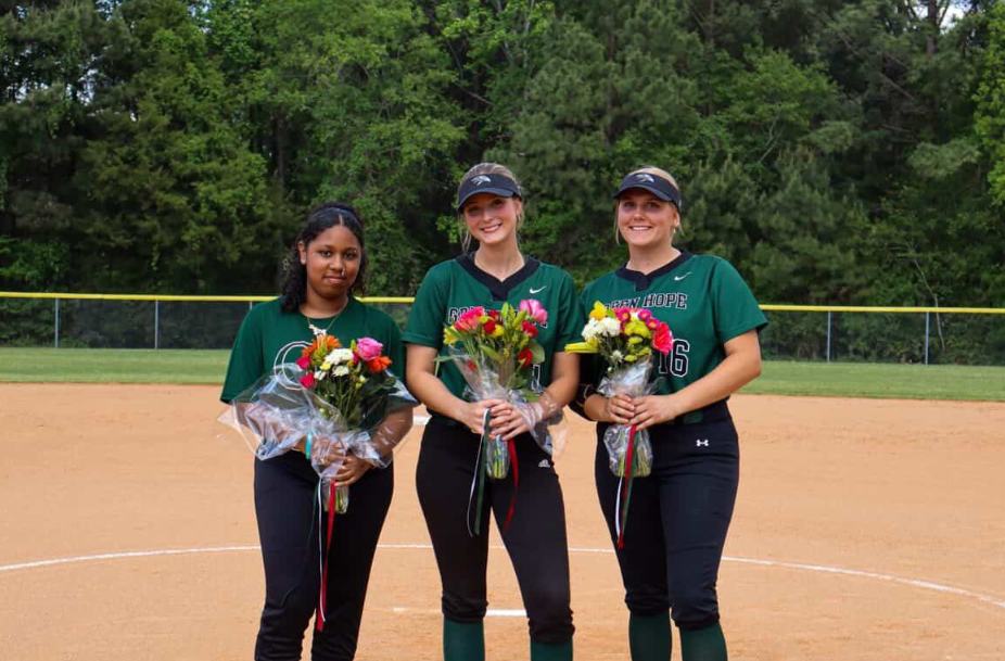 Seniors Rachael Baldyga, Sophia Cerneka and Daiyana Provencio pose on the field before April 17's game. Photo taken by Harris Seifert.