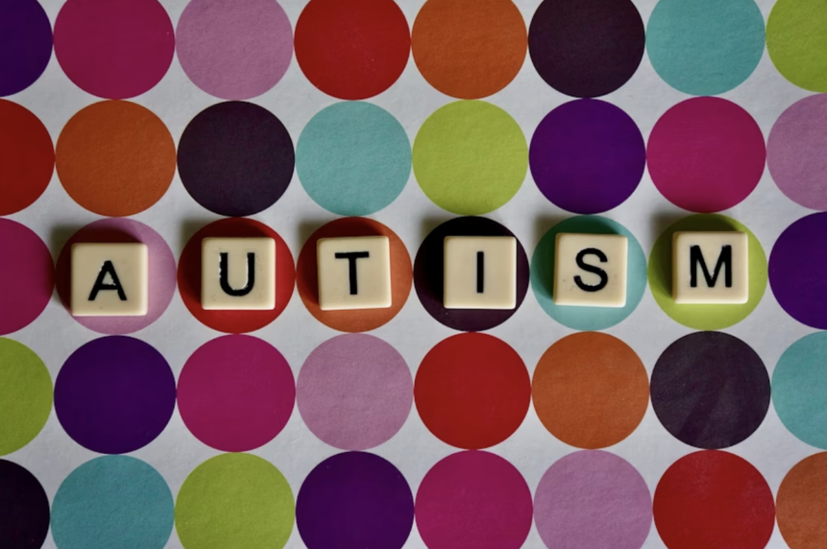 The tile letters spelling “autism” rest against a backdrop of colorful, diverse circles, representing the wide spectrum of experiences celebrated during Autism Awareness Month. Picture used with permission from Peter Burdon via Unsplash.