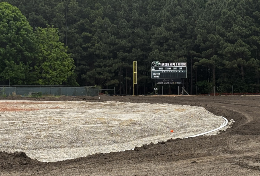 The outfield dirt meets the infield as a trench separates the two for drainage installation. 