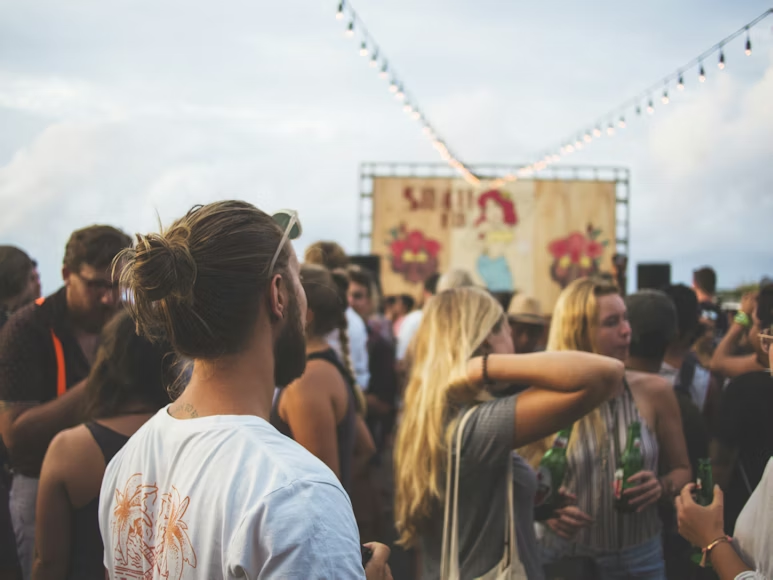 A man standing in a crowd during a concert at Coachella. Coachella is a highly-anticipated annual music festival held in Indio, California. Photo used with permission from Marvin Meyer via Unsplash.