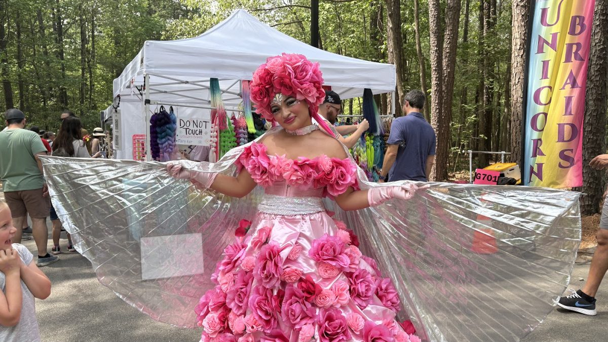 At Bond Park in Cary, NC, a young girl looks in awe at the vibrant outfit of the roving performer “Pink Rose” from the Imagine Circus at the Spring Daze Festival.