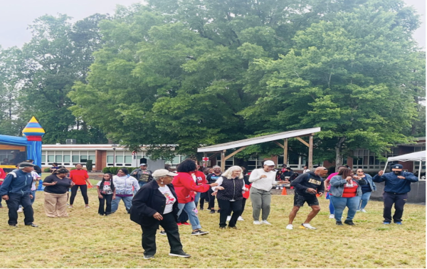 Community members line-dance near the stage during the fourth annual Orange-Chatham African American Cultural Festival in Chapel Hill, bringing performers, vendors and families together under the overcast sky.