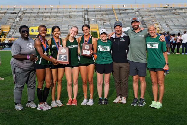 An image of the girls hoisting the State Championship runner-up plaque, joined together by the likes of the 4x400 and the coaching staff. Image provided by the Green Hope Athletic page.