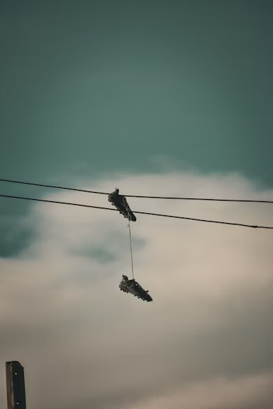 A pair of shoes hanging from a wire. Photo used with permission from Sebastian Laverde on Unsplash.